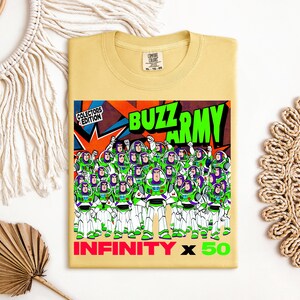 Puede incluir: Camiseta amarillo claro con un dise&ntilde;o de Buzz Lightyear y el texto "BUZZ ARMY". El dise&ntilde;o incluye m&uacute;ltiples figuras de Buzz Lightyear en verde y blanco, con "INFINITY x 50" en la parte inferior. Es una edici&oacute;n de coleccionista.