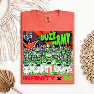Puede incluir: Camiseta de color coral con un gr&aacute;fico del Buzz Army de Buzz Lightyear. El dise&ntilde;o incluye el texto "BUZZ ARMY" en verde, "INFINITY X 50" en rojo y verde, y "COLLECTORS EDITION".