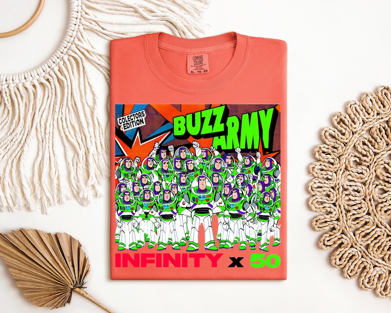Puede incluir: Camiseta de color coral con un gr&aacute;fico del Buzz Army de Buzz Lightyear. El dise&ntilde;o incluye el texto "BUZZ ARMY" en verde, "INFINITY X 50" en rojo y verde, y "COLLECTORS EDITION".