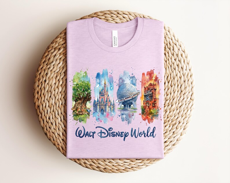 May include: A light purple t-shirt featuring watercolor illustrations of iconic Walt Disney World landmarks. The shirt includes images of the Tree of Life, Cinderella Castle, Spaceship Earth, and Tower of Terror, with the words "Walt Disney World" in script.