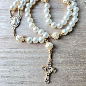 Handmade Catholic pearl rosary with gold crucifix, miraculous medal and ivory pearl beads. Religious gift for women and prayer devotion.