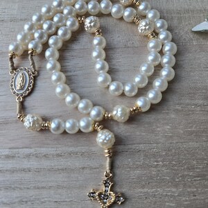 Handmade Catholic pearl rosary with gold crucifix, miraculous medal and ivory pearl beads. Religious gift for women and prayer devotion.