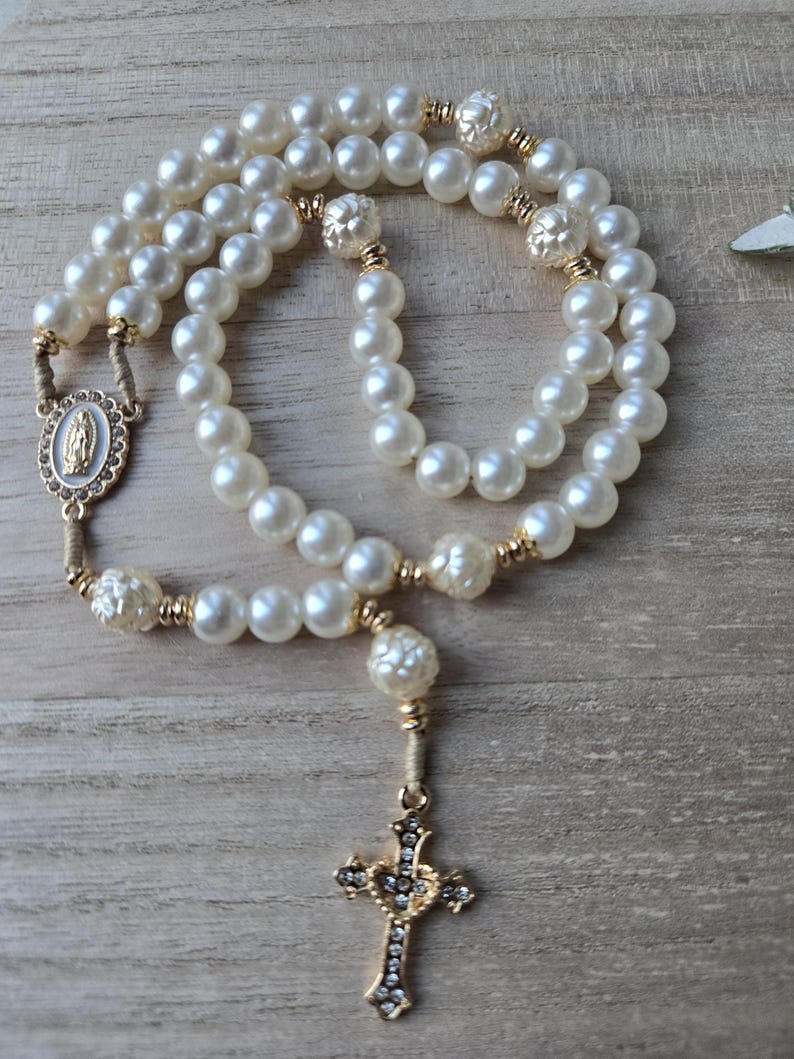 Handmade Catholic pearl rosary with gold crucifix, miraculous medal and ivory pearl beads. Religious gift for women and prayer devotion.