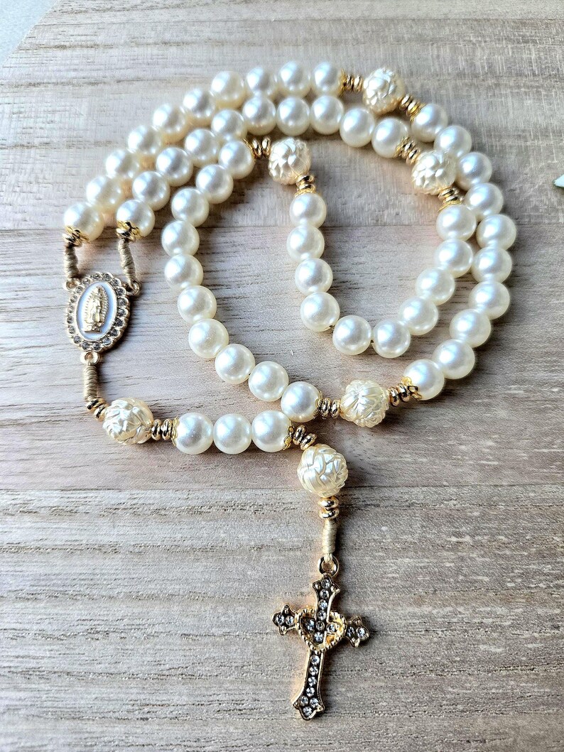 Handmade Catholic pearl rosary with gold crucifix, miraculous medal and ivory pearl beads. Religious gift for women and prayer devotion.