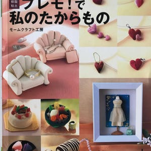May include: A book cover with the title "Premo! My Treasures" in Japanese. The cover features a variety of miniature clay creations, including a sofa, a cake, a fruit salad, a dress, and a roll of cake. The book is about making miniature clay creations.