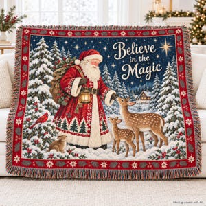 May include: A woven throw blanket featuring a scene of Santa Claus in a red coat holding a lantern, a deer, a fawn, and a rabbit in a snowy forest. The text reads Believe in the Magic. The blanket has a red border with white floral patterns.