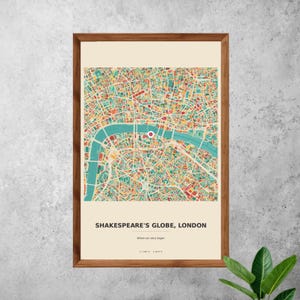 Könnte beinhalten: Ein gerahmter Druck einer Londoner Karte, die eine farbenfrohe, abstrakte Darstellung des Stadtlayouts zeigt. Die Themse ist in Türkis hervorgehoben, mit einer roten Markierung, die Shakespeares Globe anzeigt. Der Text unten lautet "SHAKESPEARE'S GLOBE, LONDON".