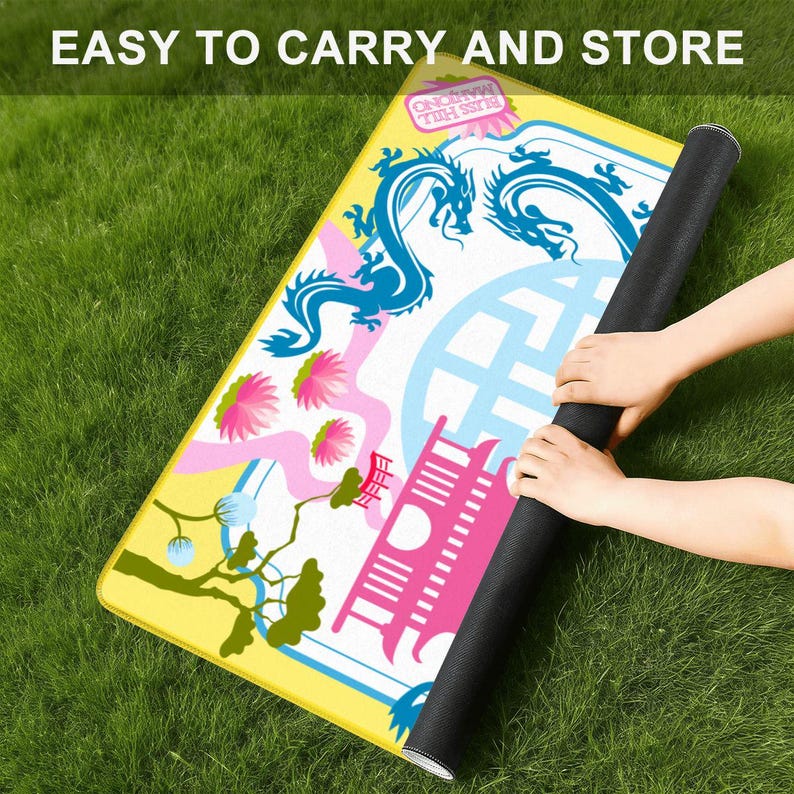 May include: A colorful mat with a dragon design is rolled up, held by hands. The mat features a yellow border, a blue dragon, pink flowers, and the text "EASY TO CARRY AND STORE". The mat is on a green grassy surface.