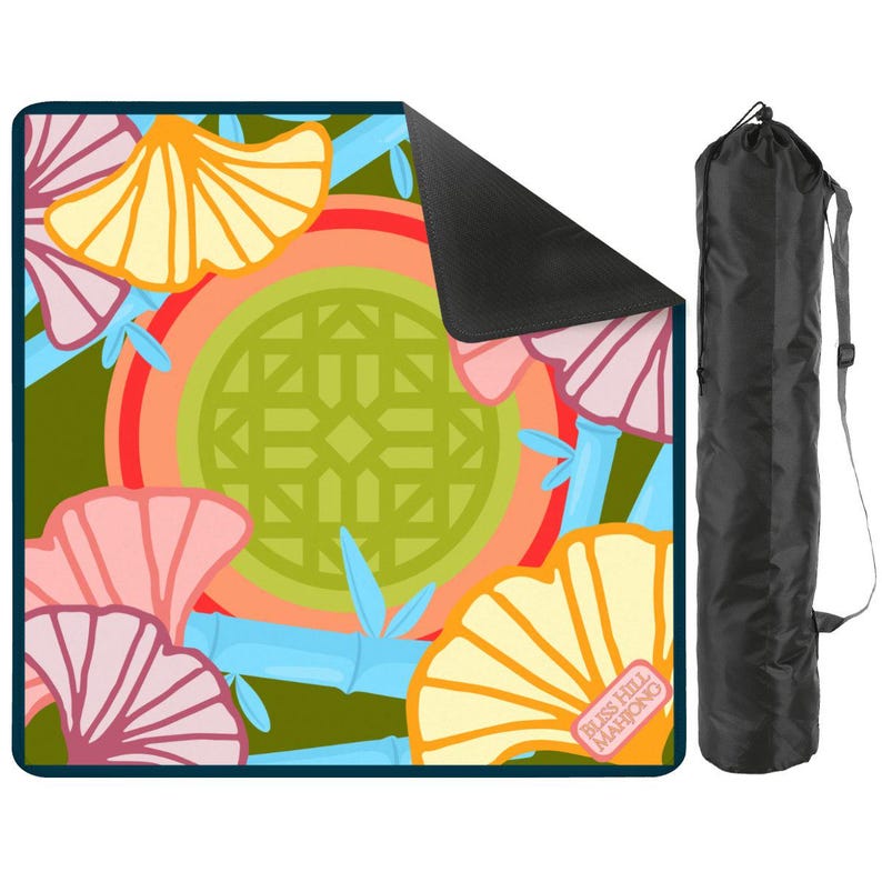 May include: A colorful Mahjong mat with a floral design in shades of orange, pink, and green, with bamboo accents. The mat is paired with a black carrying bag. The text "Bliss Hill Mahjong" is visible on the mat.