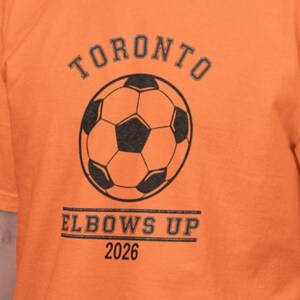Camiseta de Toronto Soccer 2026 con codos hacia arriba, Comfort Colors®
