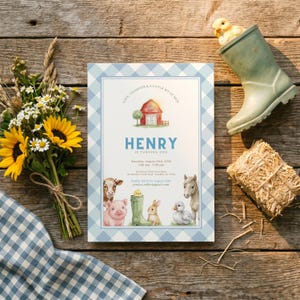 Pode incluir: Um convite com tema de fazenda com uma borda azul xadrez, apresentando uma ilustração de celeiro vermelho e o texto "HENRY IS TURNING ONE". O convite é cercado por girassóis, uma bota de borracha com um pintinho e um fardo de feno.