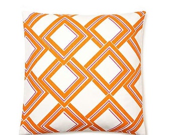 May include: Orange and white geometric patterned throw pillow with a diamond design.