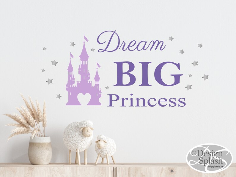 May include: Purple castle silhouette with a heart in the center and the text "Dream BIG Princess" with silver stars around the castle.