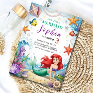 May include: A mermaid-themed birthday invitation with the text "OUR LITTLE MERMAID Sophia is turning 3". The invitation features Ariel, starfish, and other sea creatures. The invitation is on a woven mat.