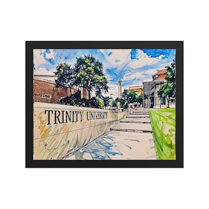 May include: Framed watercolor painting of Trinity University campus. The artwork features the university name on a concrete wall, a pathway, buildings, trees, and a tower under a blue sky with clouds. The painting is in a black frame.