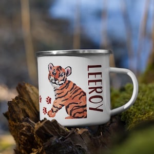 May include: White enamel mug with a watercolor illustration of a tiger cub and the name "LEROY" in maroon. The tiger cub is orange and black with red paw prints below.