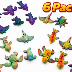May include: A collection of colorful, miniature sea creatures, including octopuses, stingrays, and fish, in a variety of vibrant colors. The text "6 Pack!!" is displayed in a yellow and red font, indicating a set of six items.