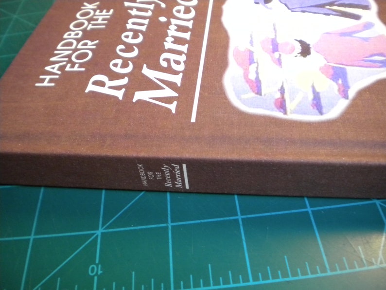 May include: A brown book with the title "Handbook for the Recently Married" in white text. The book has a colorful illustration of a couple on the front cover.
