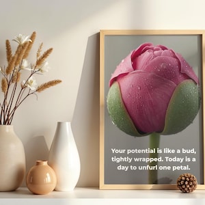 Könnte beinhalten: Ein gerahmter Druck mit einer Nahaufnahme einer rosa Pfingstrosenknospe mit Wassertropfen, gerahmt in hellem Holz. Der Text lautet: "Dein Potenzial ist wie eine Knospe, eng umschlossen. Heute ist ein Tag, um ein Blütenblatt zu entfalten."