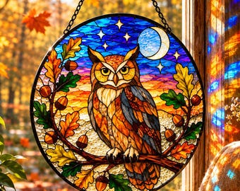 May include: A circular stained glass suncatcher featuring a central owl perched on a branch, surrounded by oak leaves and acorns. The background depicts a night sky with a crescent moon and stars, rendered in shades of blue, orange, and yellow.