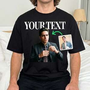 May include: Black t-shirt with the white text "YOUR TEXT". The shirt displays a large image of a man in a suit holding a cigar, and a smaller image of the same man smiling. A green arrow points to the smaller image.