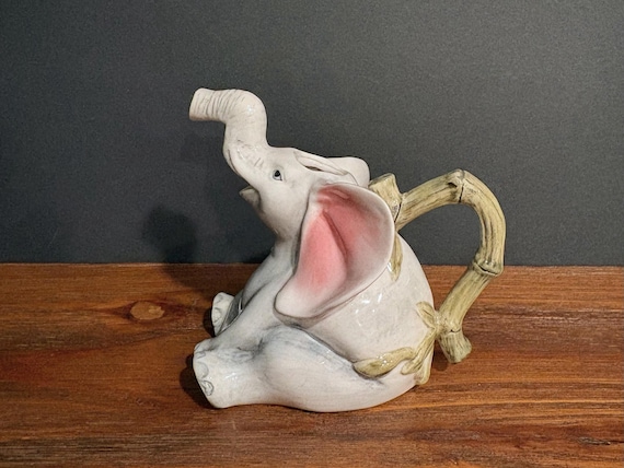 A genuinely vintage Fitz & Floyd whimsical elephant creamer with a bamboo handle — the kind of quirky collectible that sparks a story every time it's on the table.