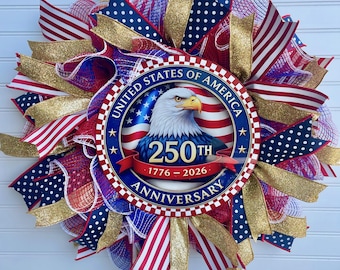 May include: A patriotic wreath with red, white, and blue ribbons, gold accents, and a central emblem. The emblem features an eagle, the text "UNITED STATES OF AMERICA", and "250th Anniversary 1776-2026".