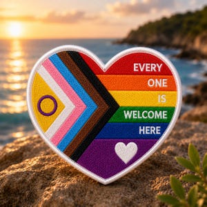 May include: Heart-shaped patch with a rainbow design and the words "EVERY ONE IS WELCOME HERE." The patch incorporates various pride flag elements, including the transgender, intersex, and progress pride flags. A white border surrounds the patch.