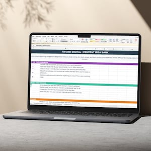 Peut inclure: Un ordinateur portable argenté affichant une feuille de calcul intitulée 4WORD DIGITAL | CONTENT IDEA BANK. L'écran présente un classeur structuré avec des listes numérotées, des en-têtes colorés en violet, bleu sarcelle et orange.
