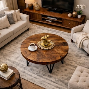 Peut inclure: Une table basse ronde en bois foncé avec des pieds en métal noir, au centre d'un salon. Une tasse de café et une figurine dorée ornent la table. Le salon comprend un canapé, un fauteuil et un tapis à motifs. La table mesure environ 100 cm de diamètre.