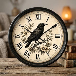 Peut inclure: Une horloge murale ronde noire avec des chiffres romains et un corbeau noir perché sur une branche. Le cadran de l'horloge est de couleur crème avec des motifs floraux. L'horloge a un cadre noir et des aiguilles noires.