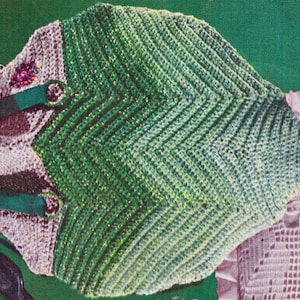 Peut inclure: Une tenue de bébé en crochet vert et blanc avec une bavette en crochet rose et blanc. La tenue a un motif chevron vert et blanc et la bavette a un motif de dentelle délicat.