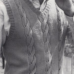 Puede incluir: Una foto en blanco y negro de un hombre que lleva un chaleco de punto de cable con una camisa blanca debajo. Está sosteniendo un palo de golf en su mano derecha.