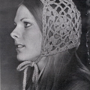 Könnte beinhalten: Nahaufnahme einer Frau, die eine gehäkelte Mütze mit einem zarten Blumenmuster trägt. Die Mütze ist unter dem Kinn mit einer langen, dünnen Schnur gebunden.