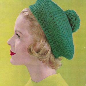 May include: A woman wearing a green crocheted beret with a pom-pom on top. The beret is made with a textured stitch.