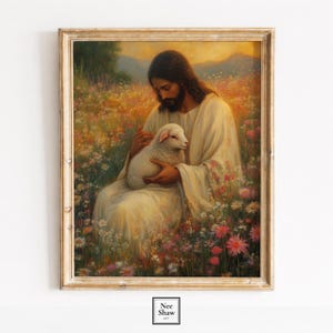 May include: A framed print depicts a figure in a white robe cradling a lamb in a field of wildflowers. The artwork features warm tones, with a golden frame and a soft, pastoral scene. The print is labeled "Nee Shaw ART".