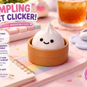 Może przedstawiać: Biały fidget clicker w kształcie pierożka z czarną uśmiechniętą buźką, umieszczony w okrągłym beżowym pojemniku. Powyżej znajduje się napis DUMPLING FIDGET CLICKER! oraz dodatkowy tekst opisujący cechy produktu, takie jak satysfakcjonujące kliknięcie.