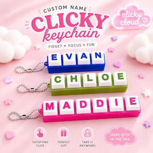 Puede incluir: Tres llaveros personalizados con teclas de teclado mecánico blancas sobre bases azul, verde y rosa. Las teclas muestran los nombres EVAN, CHLOE y MADDIE. Cada llavero cuenta con una cadena de bolas de metal plateado para sujetarlo.