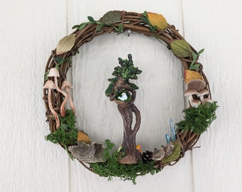 Natural 10" wreath with tree goddess cradling bird nest, with multiple mushrooms, mosses, leaves and crystals to add to the charm.