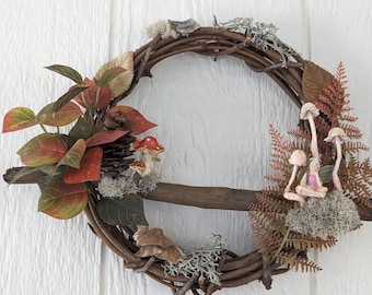 10" Fairy wreath with fall foliage, mushrooms and of course - a fairy sitting in a tuft of moss.