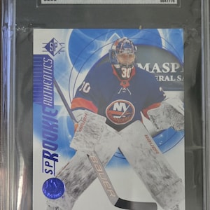 Puede incluir: Una tarjeta de hockey con Ilya Sorokin, portero de los New York Islanders. La tarjeta está calificada con 10 por SGC e incluye el texto "Rookie Authentics" y "2020-21 Upper Deck SP". La tarjeta está dentro de un soporte protector.