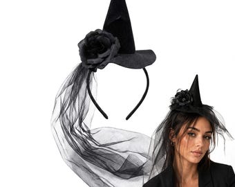 May include: A black witch hat headband featuring a pointed cone shape, a wide brim, and a large black fabric rose attached to the side. A long, sheer black tulle veil hangs from the base of the hat, which is mounted on a thin black headband.