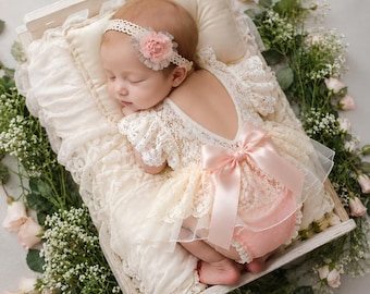 Conjunto de pelele de encaje para recién nacido con diadema y flores, ideal para fotografía.