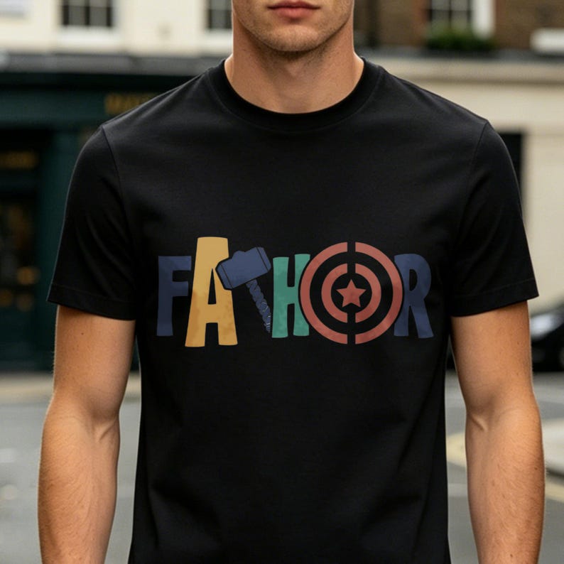 May include: Black t-shirt with the word "FA THOR" in colorful letters and graphics. The "A" is yellow, the "TH" has a blue hammer, the "O" is green, and the "R" is a red target with a star.