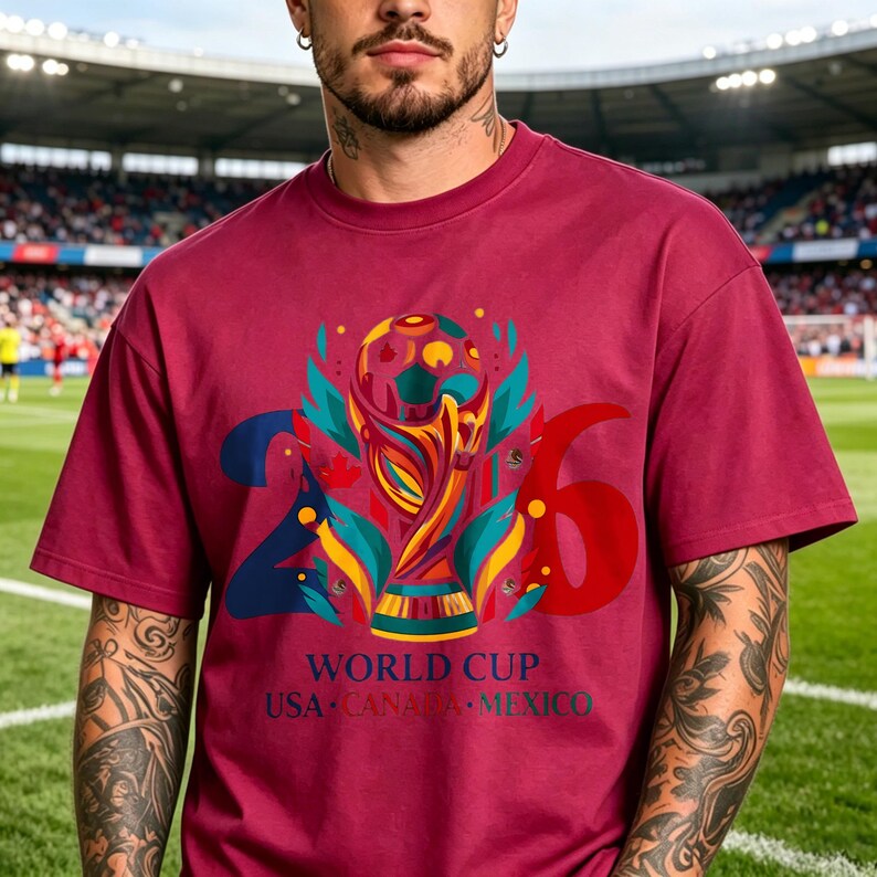 Puede incluir: Una camiseta de manga corta color granate con un gr&aacute;fico del trofeo de la Copa del Mundo centrado entre los n&uacute;meros 2 y 6. Debajo del gr&aacute;fico, el texto dice WORLD CUP USA CANADA MEXICO en letras azules y verdes en la parte frontal.