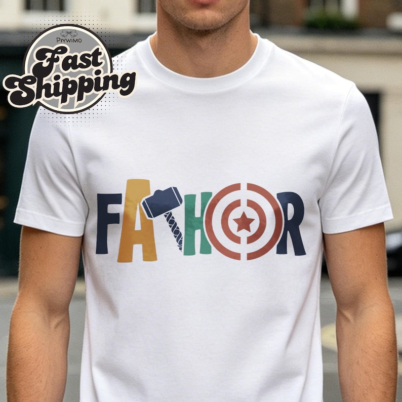 May include: White t-shirt with the word "FATHOR" in colorful block letters. The "A" is a hammer, the "H" is a green and blue design, and the "O" is a target with a star in the center.