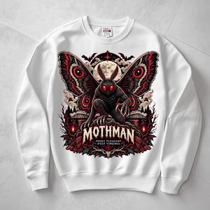 Può includere: Una felpa bianca a girocollo con una stampa grafica di una creatura alata scura con occhi rossi luminosi. Il design include il testo MOTHMAN POINT PLEASANT WEST VIRGINIA, una luna piena, pipistrelli e accenti floreali rossi su uno sfondo nero.