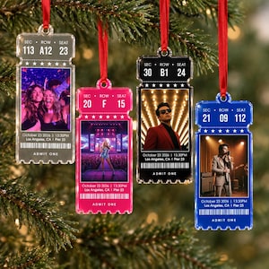 May include: Four rectangular acrylic ornaments shaped like concert tickets, each hanging from a red ribbon. The tickets feature custom photo prints, seat information, the date October 23 2026, Los Angeles, Pier 23, and the text ADMIT ONE.