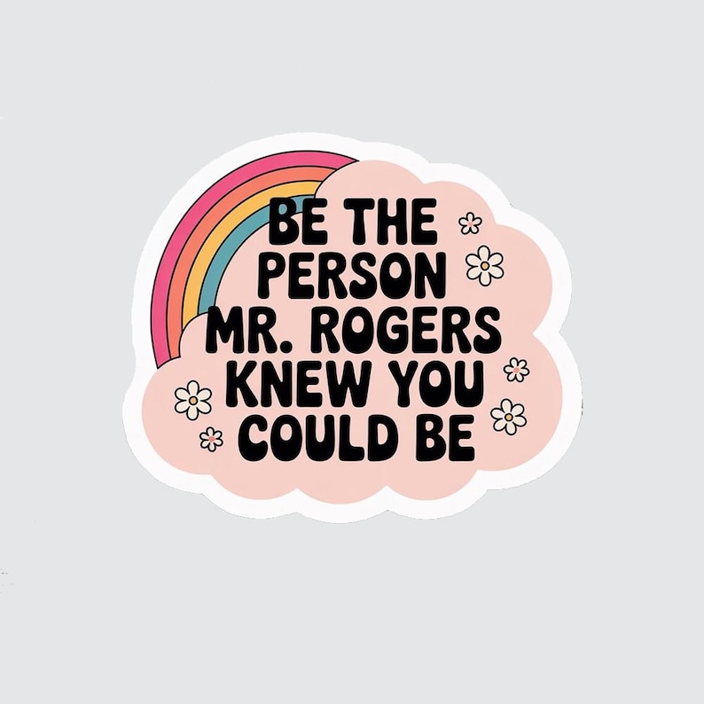 May include: A sticker with the text "BE THE PERSON MR. ROGERS KNEW YOU COULD BE" in black font. The text is on a pink cloud shape with small white flowers. A rainbow arches over the text.
