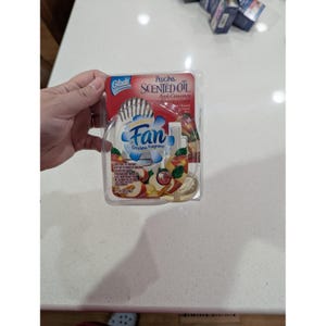 May include: A Glade PlugIns Scented Oil air freshener in a clear plastic package. The product features a fan design with the words "Fan Circulates Fragrance". The scent is Apple Cinnamon, with images of apples and cinnamon sticks.
